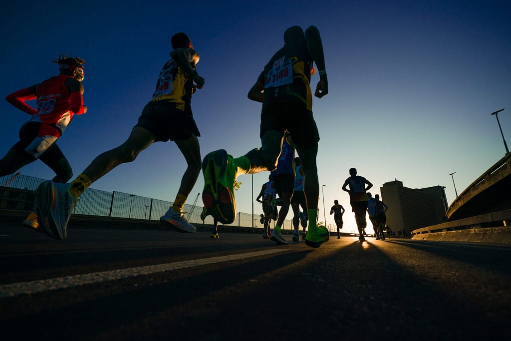 A silhouette of Cape Town Marathon runners on a road on the route