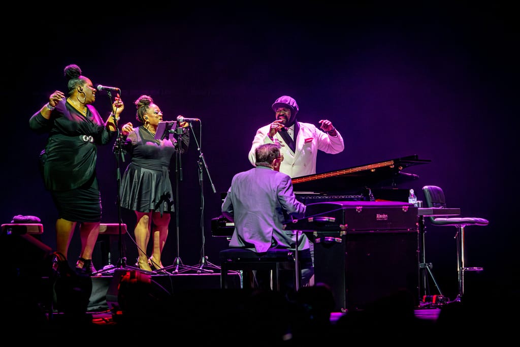 Gregory Porter on stage with back up singers and pianist.