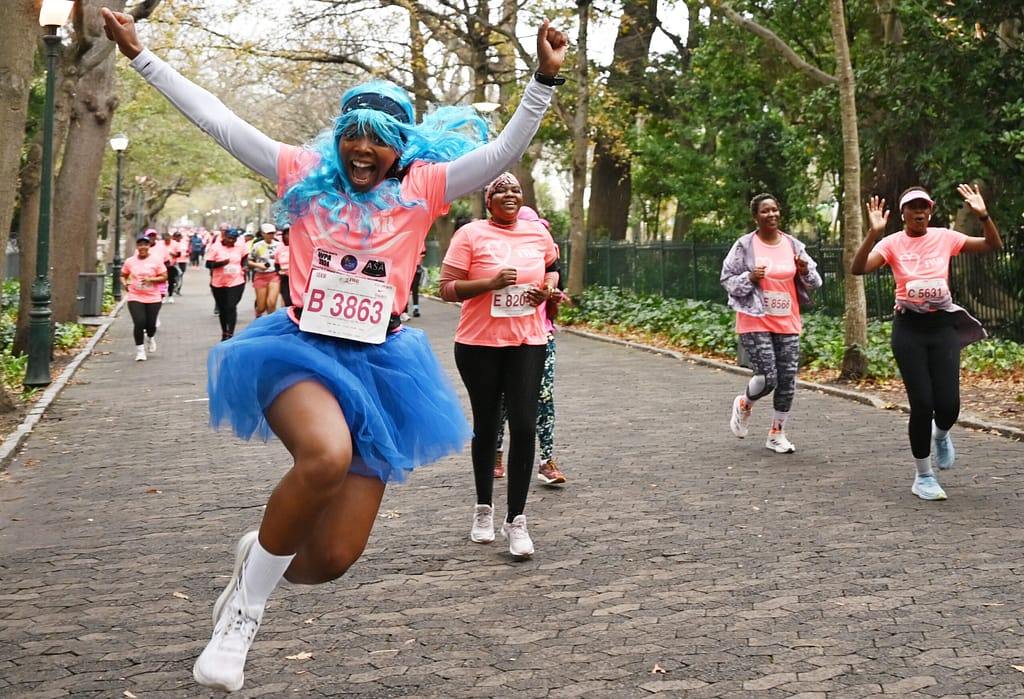 A Totalsports Women's Race participant jumps in the air at the Company's Garden during the 2024 race