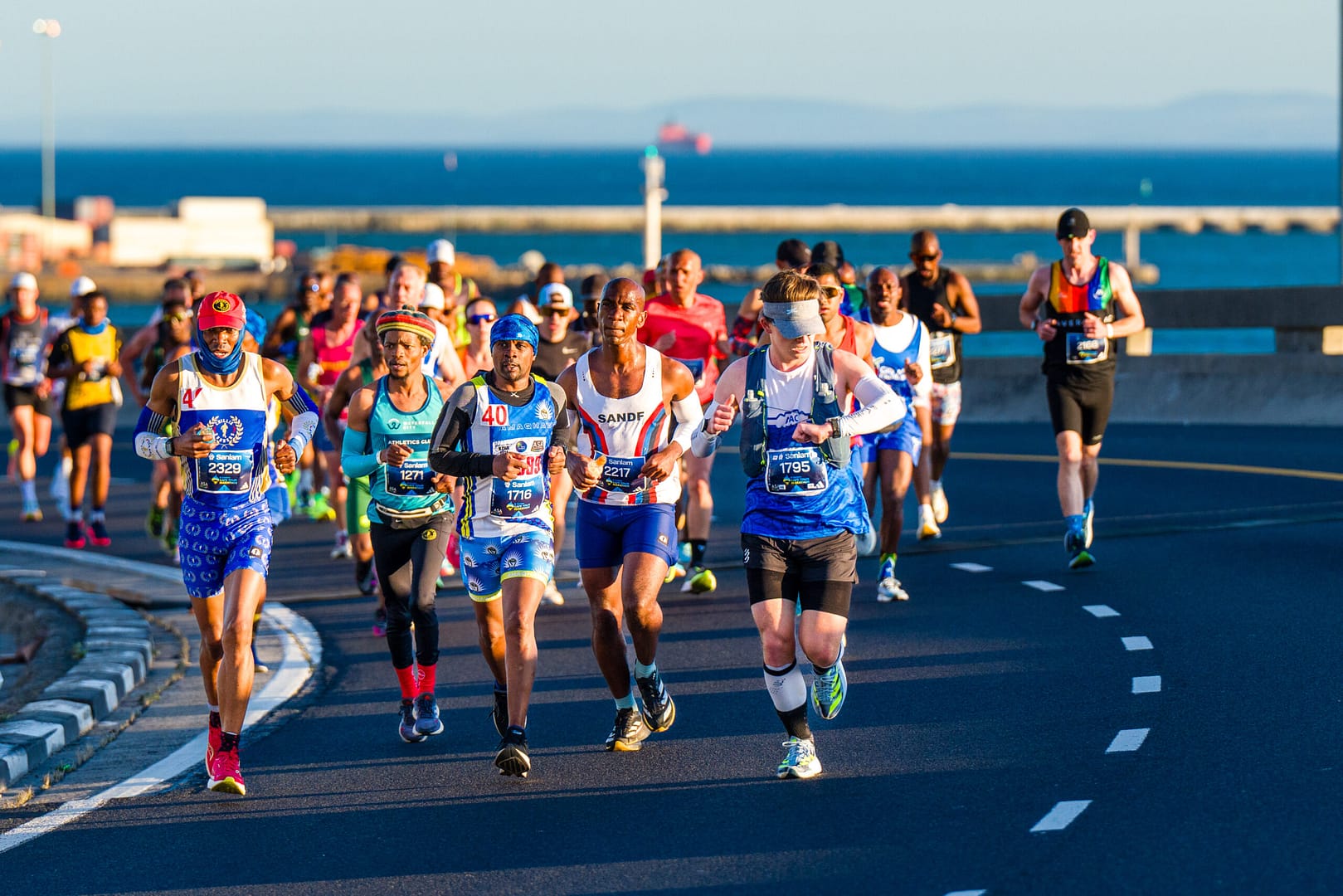 Batch of Cape Town Marathon runners on the Elevated Freeway with the Atlantic Ocean in the distance