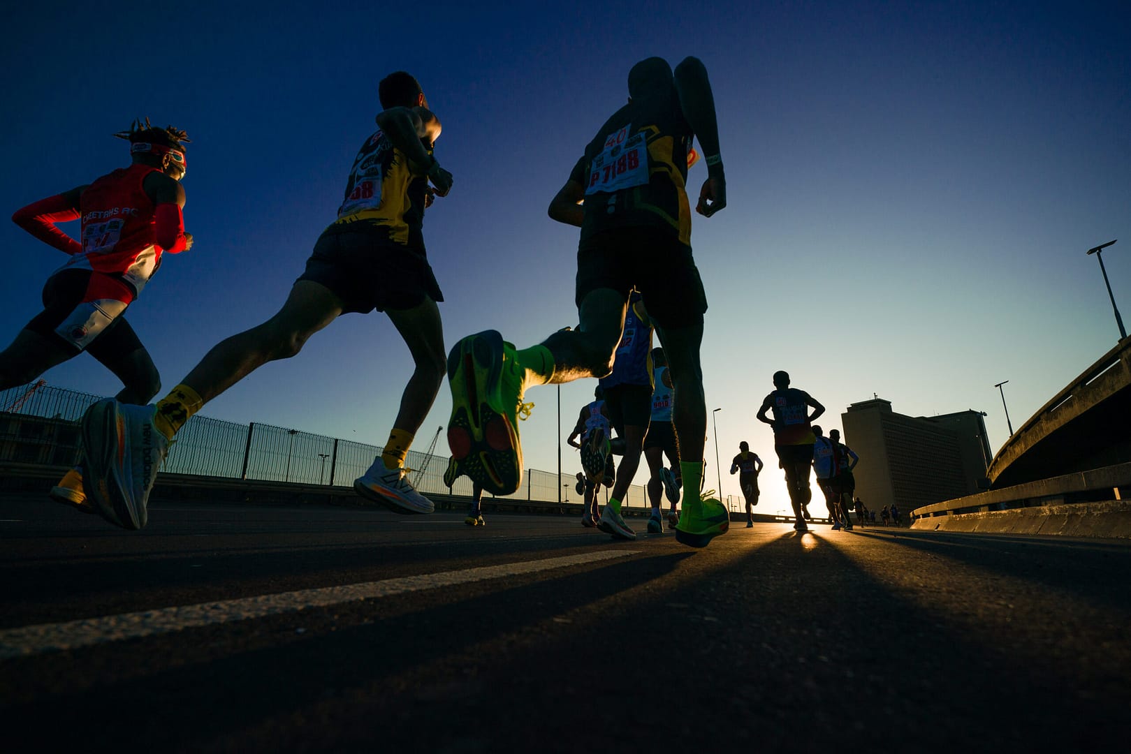 A silhouette of Cape Town Marathon runners on a road on the route